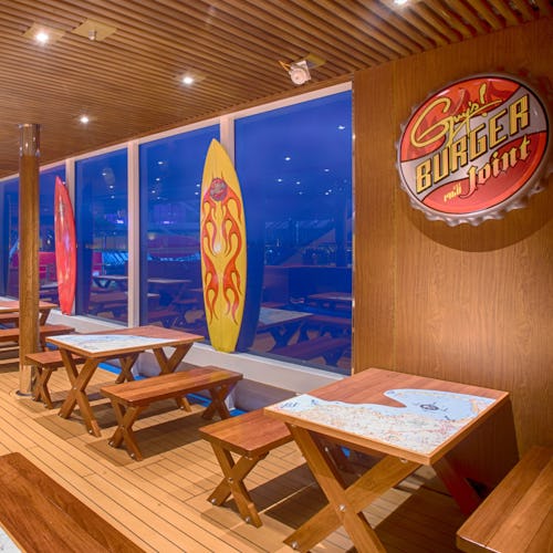 Tables set at Guys Burger Joint with views of the ocean