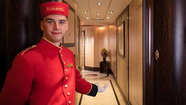 A bellboy welcoming guests to their Suite onboard Cunard