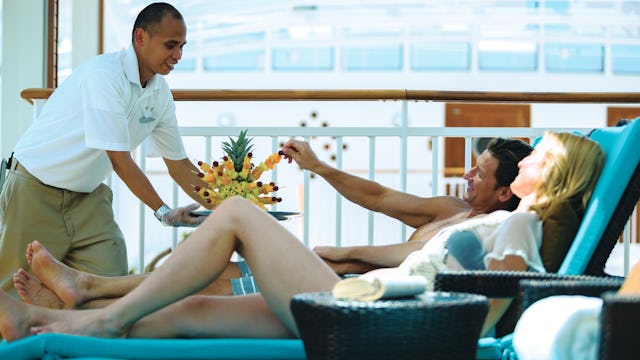 Couple being served fresh fruit in the Haven onboard Norwegian Breakaway