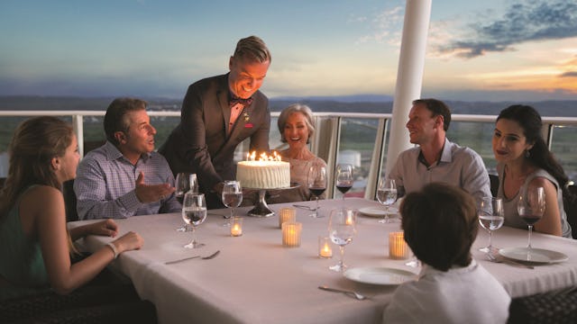 A Royal Genie serving a birthday cake to suite guests