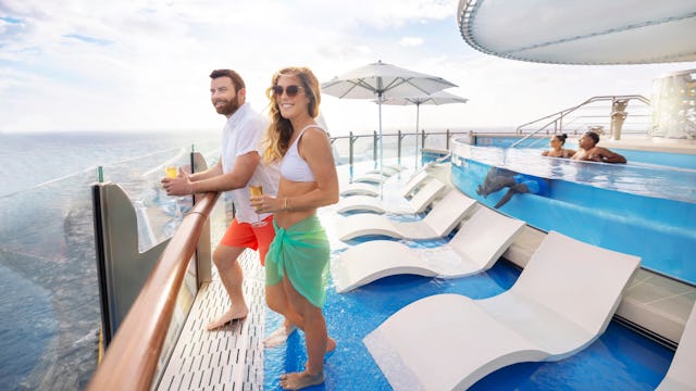 A couple enjoying drinks by the pool on Royal Caribbean