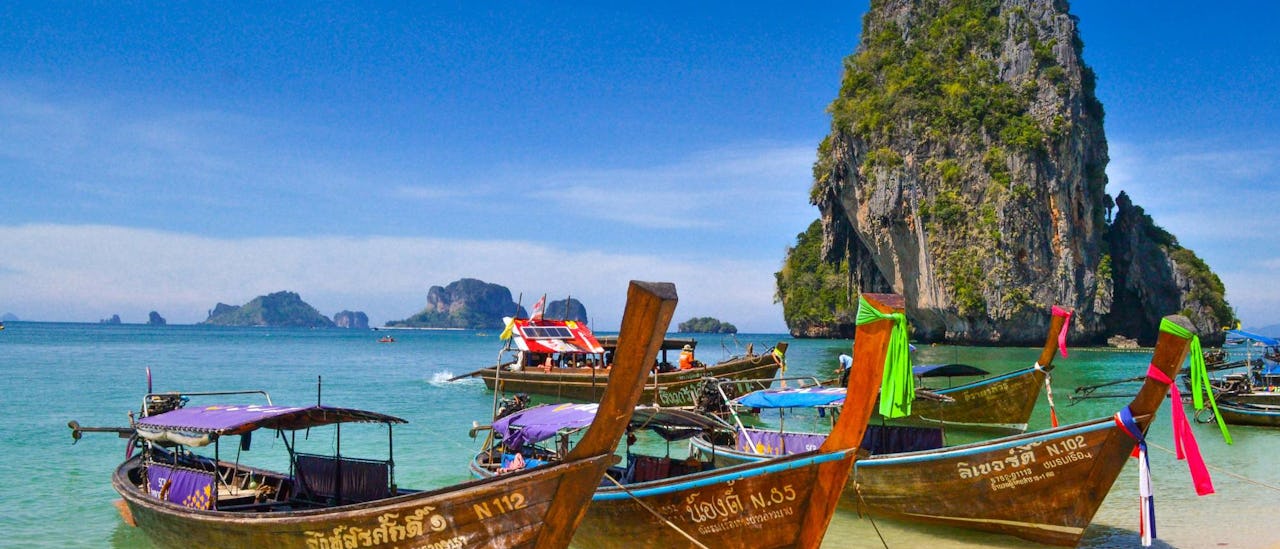 Traditional longtail boats on a beach in Phuket, Thailand.