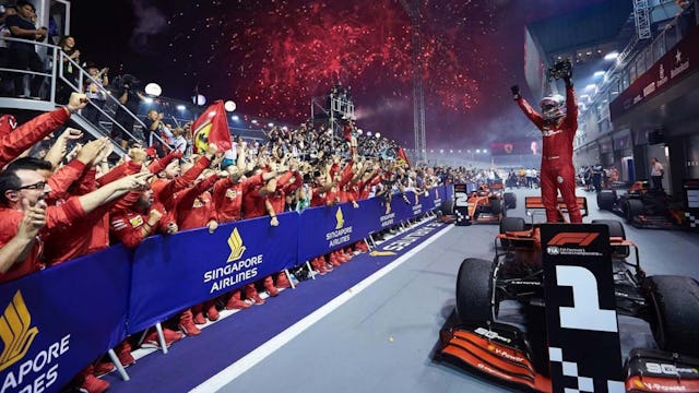 Ferrari is celebrating the Singapore Grand Prix win as Paramount Cruises customers look on from the grandstands.