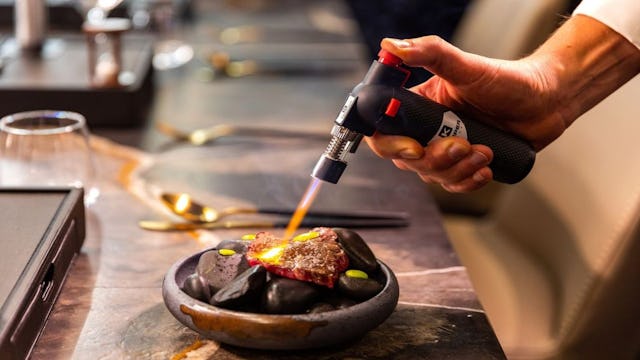 Steak cooked on hot stones with a blow torch