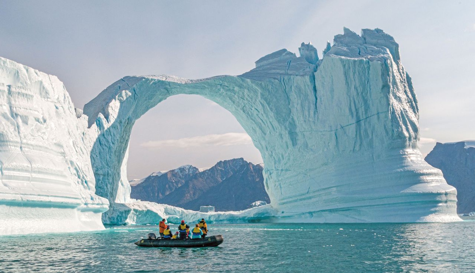 Zodiac boat in Antarctica showing an ice arch formation