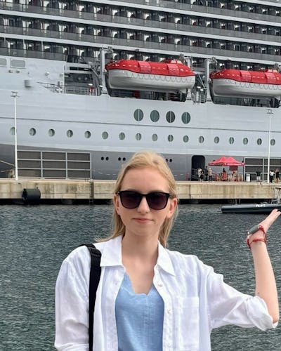 Monika on holiday in front of a Virgin Voyages ship