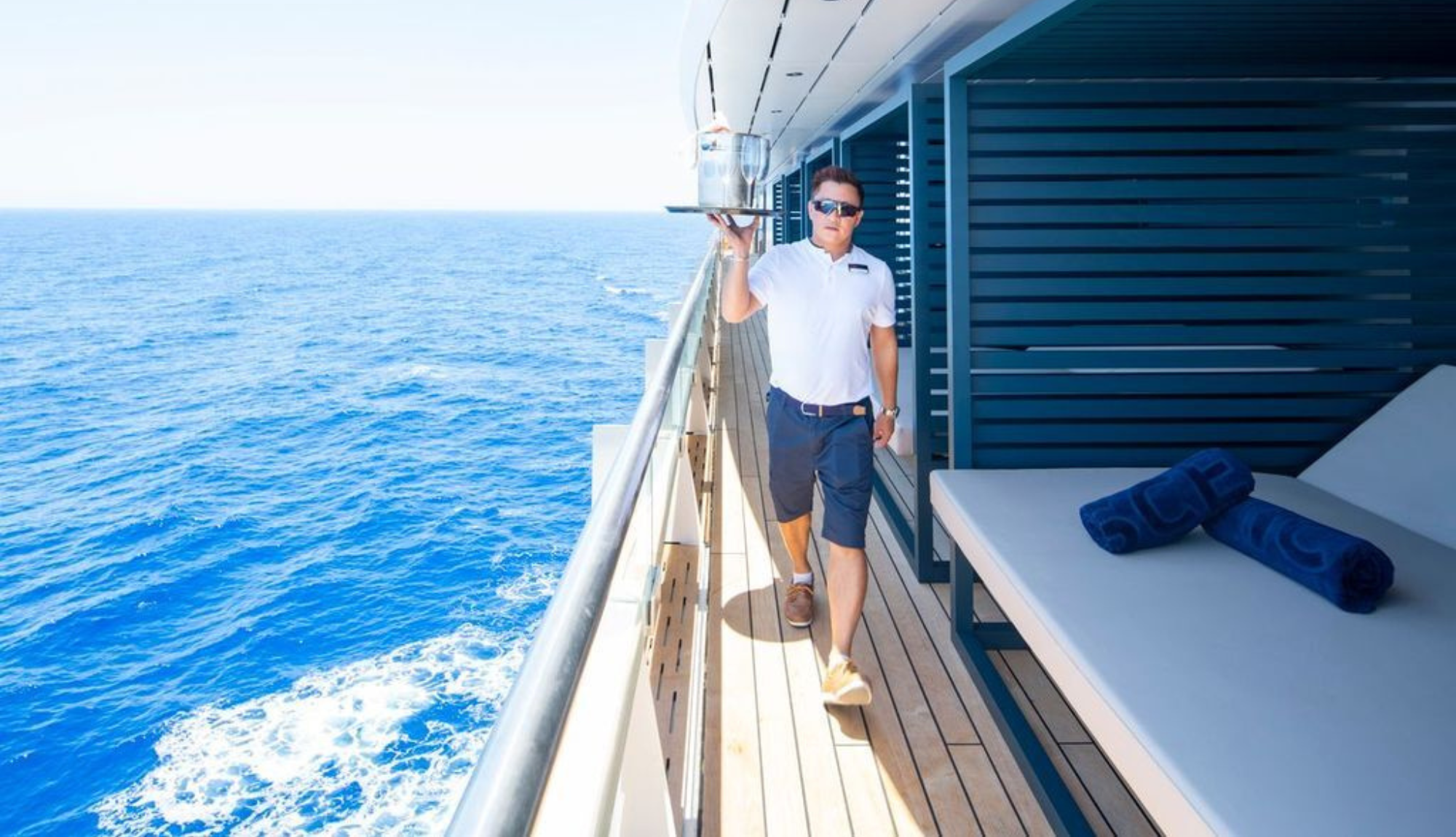 Scenic Cruise Waiter Serving Drinks To Sun Lounger Area