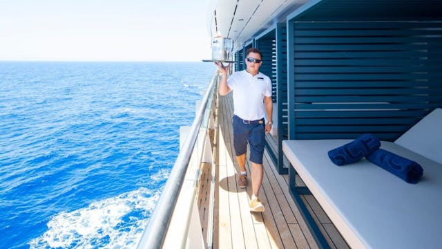 Scenic Cruise Waiter Serving Drinks To Sun Lounger Area