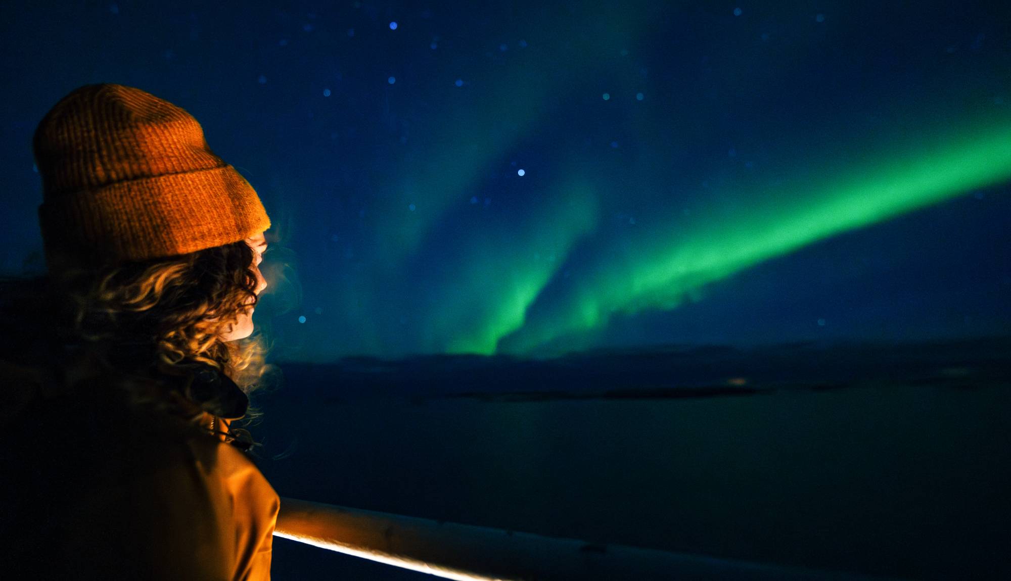 Hurtigruten Northern Lights Cruises - Guest watching the Aurora Borealis from a Hurtigruten ship in Alta, Norway