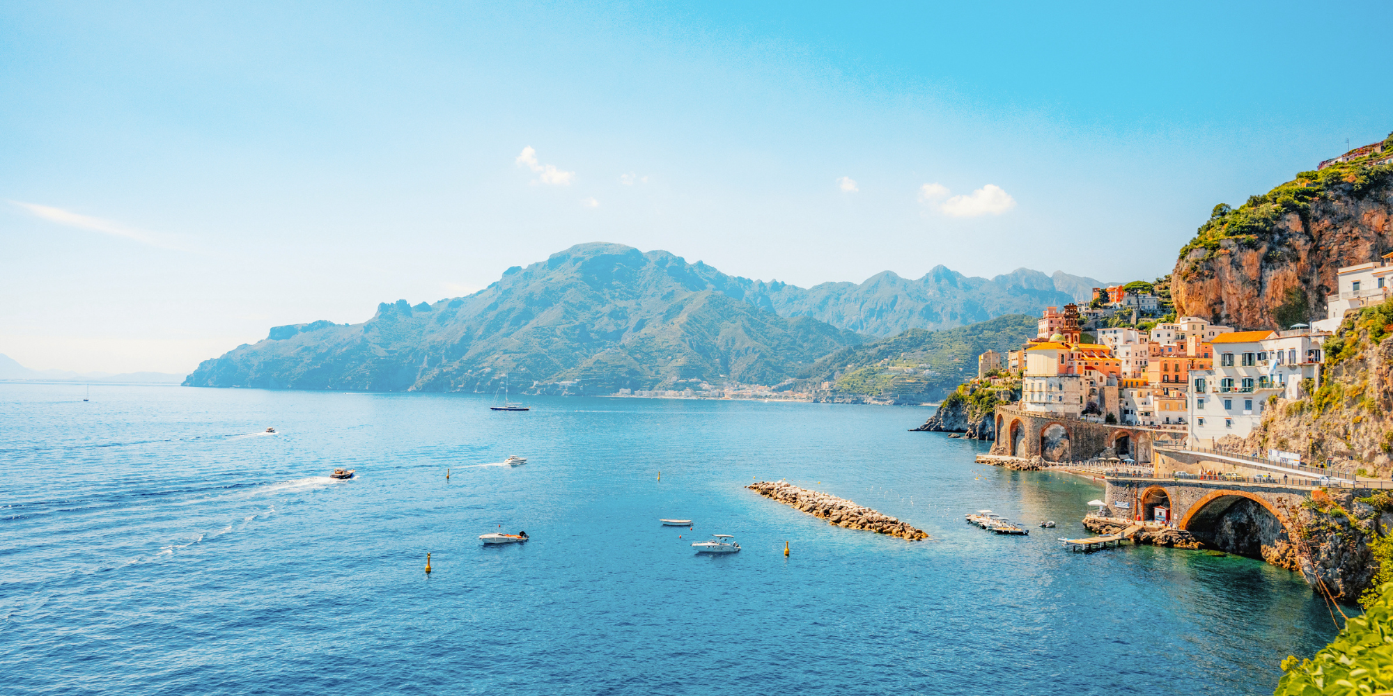 Coastline in Italy with shot of cliffside buildings & ocean.