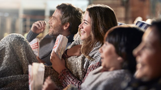 Family enjoying popcorn watching a movie under the stars