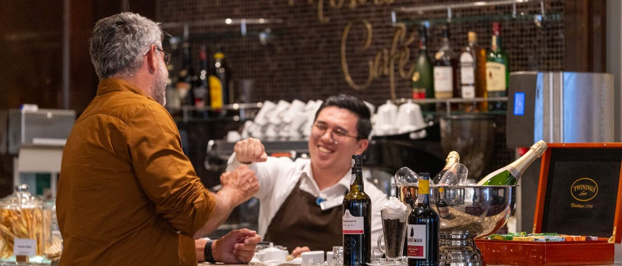 Barman interacting with guest at Mosaic Cafe onboard Azamara